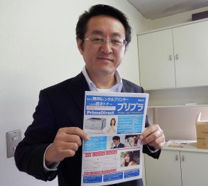 パンフレットを手にする鈴木社長