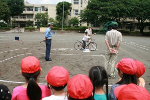 自転車に乗って運転を学ぶ児童