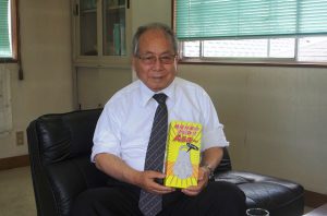 製品を手にする駒沢化成の河野社長