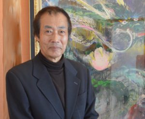 自作の絵画を背に神田社長