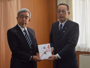 目録を加山市長に手渡す山本氏（左）