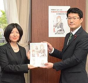 マンガを受け取る阿部議長(右)