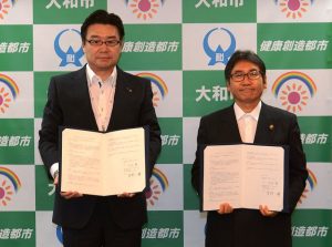 協定書を手にする大木市長（右）と星野支社長