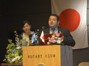 檀上からあいさつするメンドーサ臨時代理大使