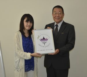 井上理事長と作品を持つ山浦さん（左）