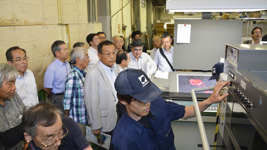 新印刷機を見学する講演会参加者ら