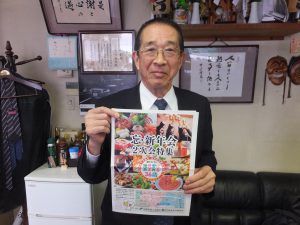 チラシを手にする志村社長