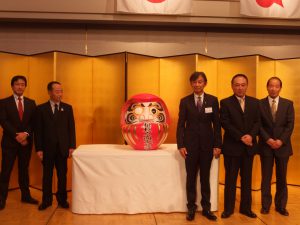 寄贈されただるまに目を入れる杉浦会頭