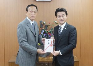 目録を手渡す田中社長（右）