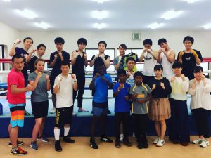 一橋大ボクシング部のメンバーに囲まれる選手と岡川さん（前列左）