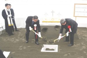 聖書を地中に収める「定礎」を行う佐藤理事長ら