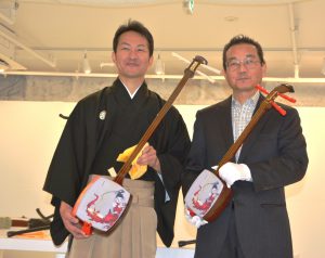 胡弓型の三味線を持つ小松社長(右)