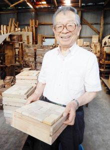 積み木の木箱を持つ吉田社長