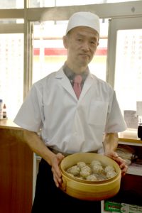 シウマイを持つ店主の植田さん